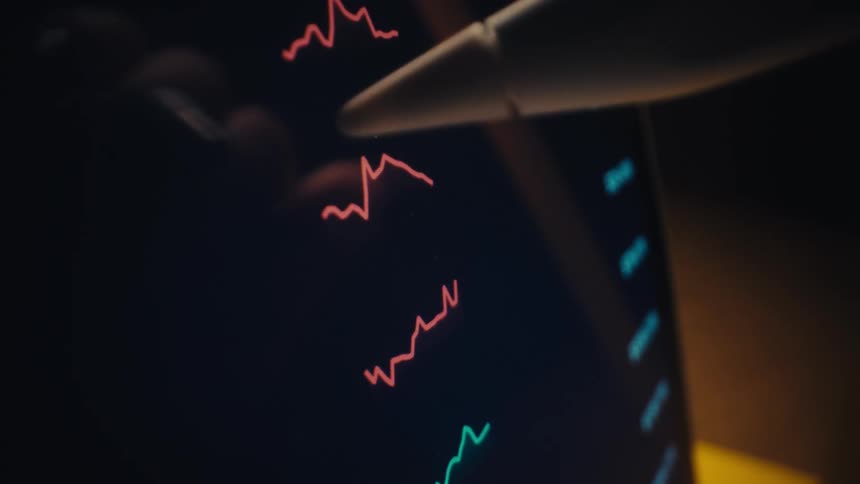 Digital pen pointing to colored line charts on a dark financial interface