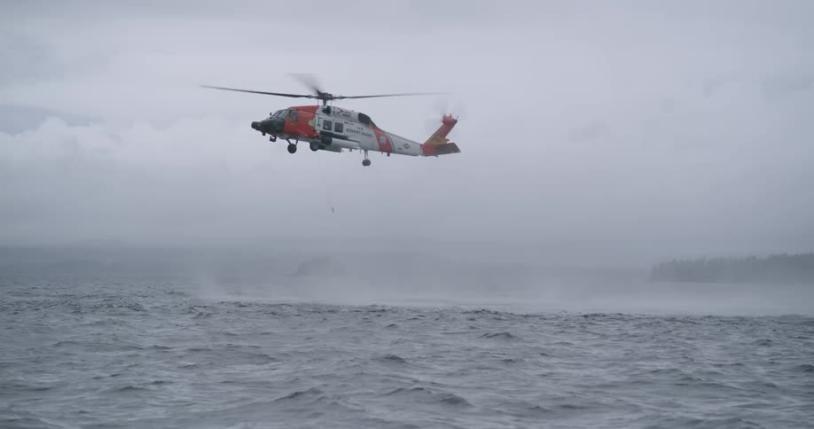 The helicopter is hovering over the ocean in rough waves