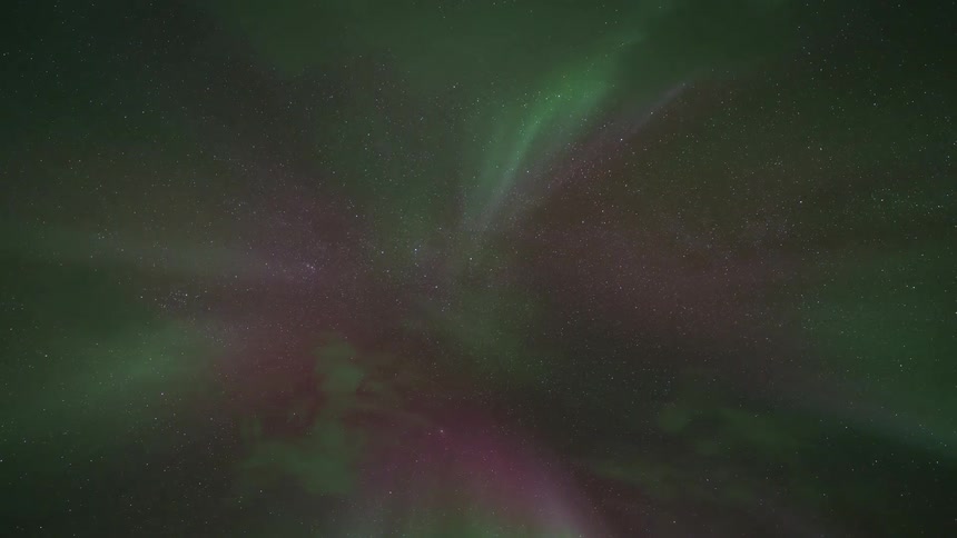Colorful glowing lights of the aurora borealis twist and turn across the night sky