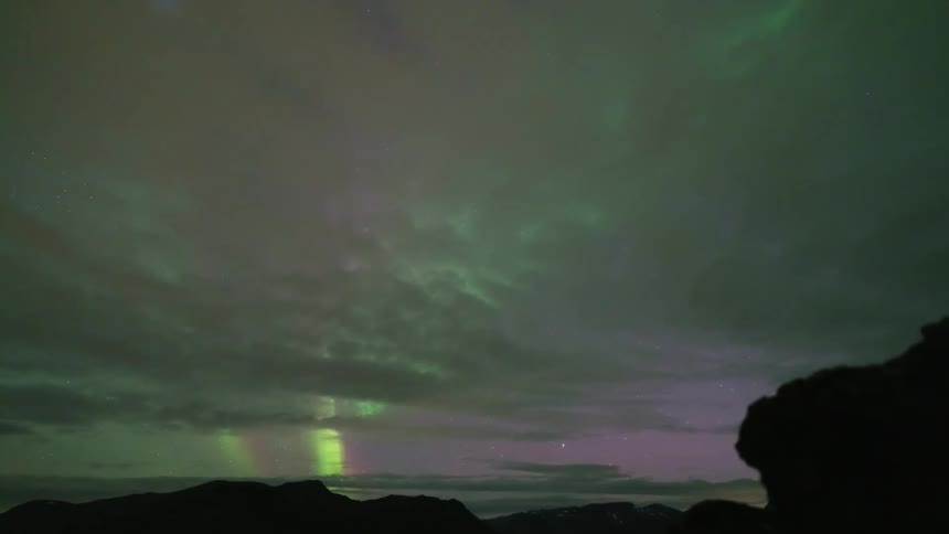 The cloudy sky is green from the northern lights