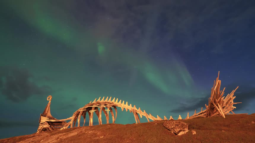 Viking shipshaped sculptural installation under green aurora borealis at night