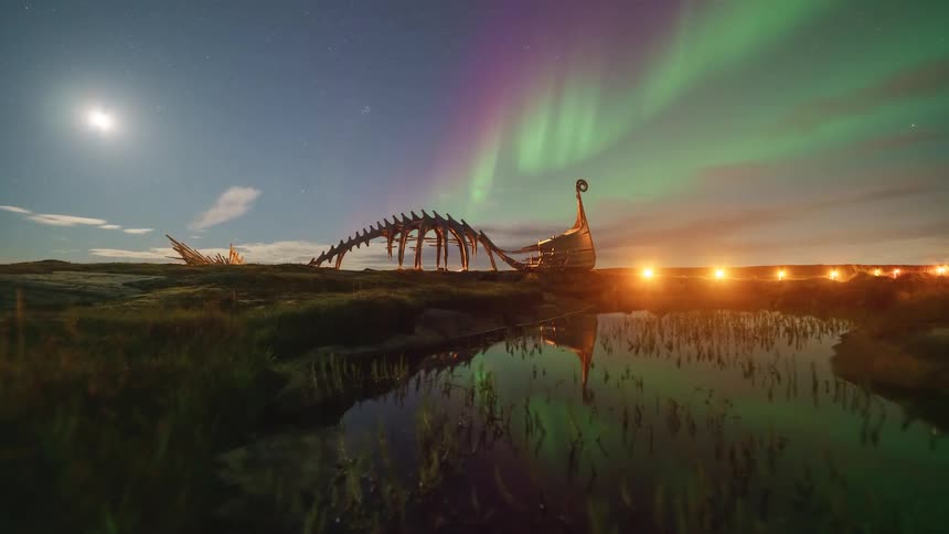 A dinosaur dig site sits out in the wild at night and exposed bones illuminated by a focused beam of artificial light above the quiet scene a soft green light hovers in the sky