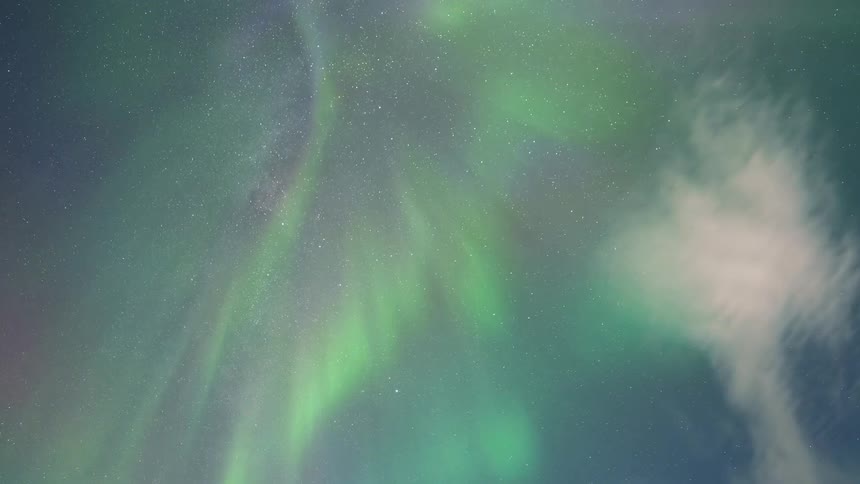 The northern lights shine green in the starry sky