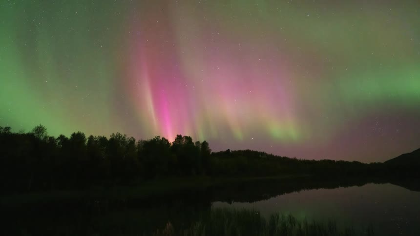 The multi colored northern lights wave in the night sky