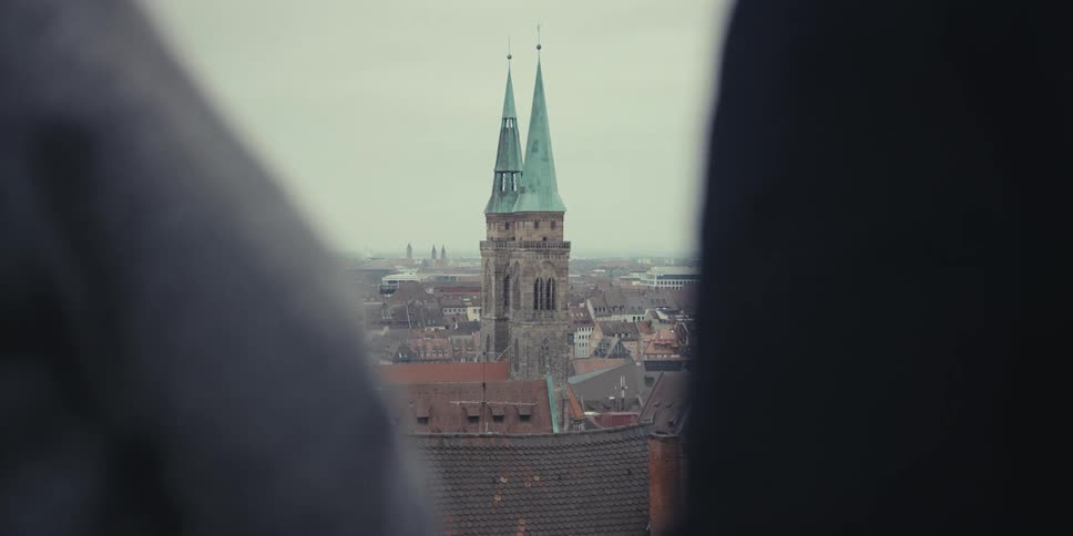 Tourists hold hands while looking out over the city