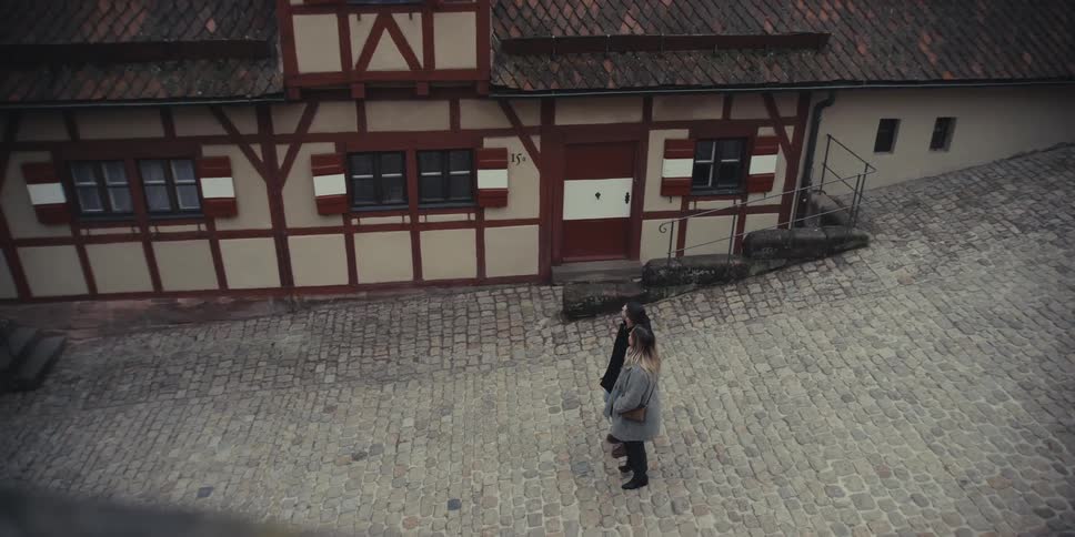 Couple holding hands walking through a village