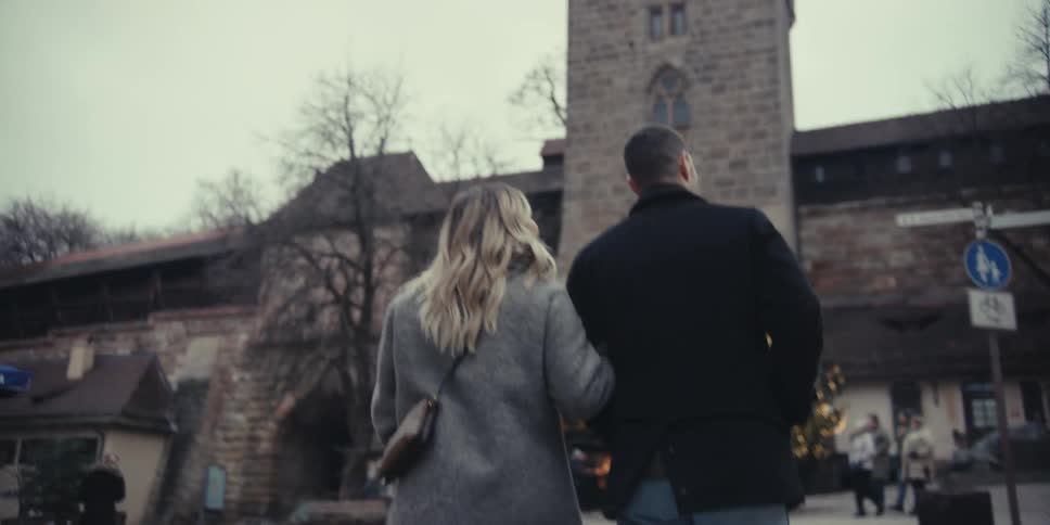 Couple walking hand in hand in a setting of classical architecture