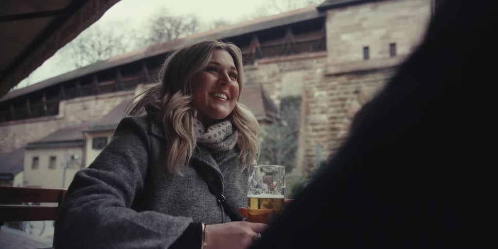 Toast with beer glasses at an outdoor table in front of a historic building