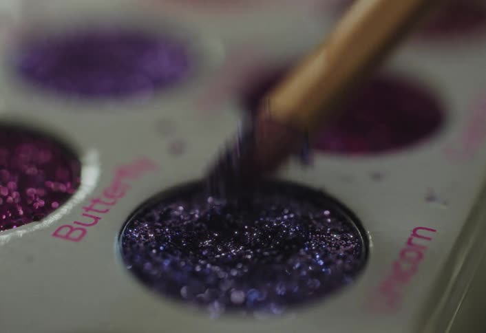 A brush in a palette of makeup