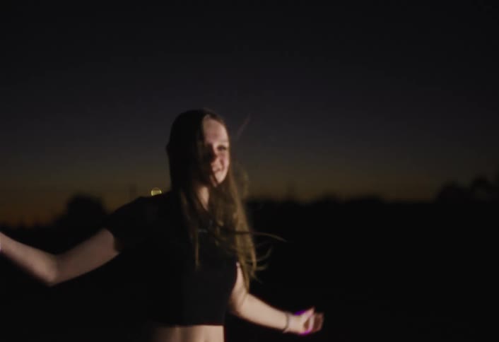 A woman dancing and jumping outdoors