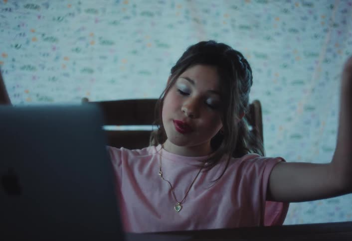 A child talking on a laptop in a room