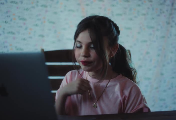 A girl speaks enthusiastically to a laptop