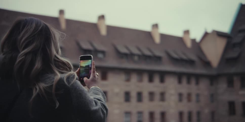 A man and woman taking photos together outside