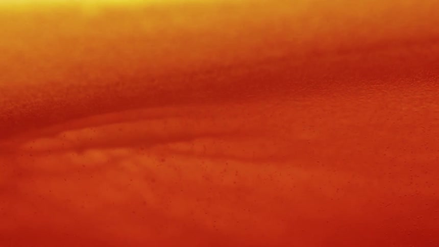 Wave flows across the surface of an orange mixture