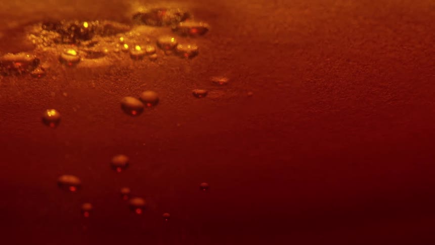 Closeup of amber liquid with suspended bubbles