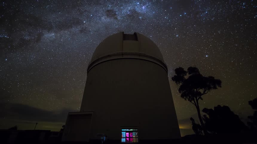 In this video a massive astronomical observatory dome stands silhouetted against a breathtaking starfilled night sky the milky way galaxy stretches vividly across the background while the stars appear to rotate slowly over the darkened landscape