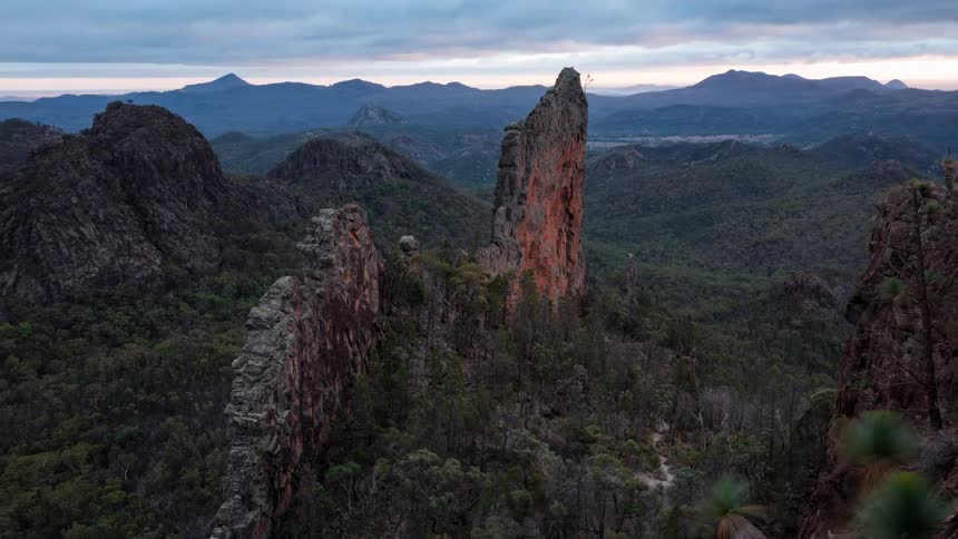 Sunlight shining from the horizon briefly tints the mountainous terrain red as the day progresses