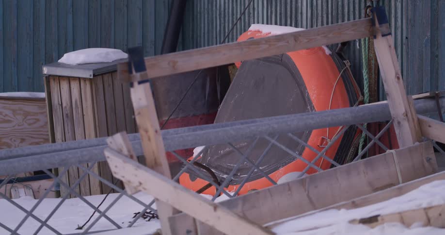 A sled propped up against the side of a building