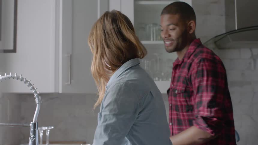 A woman and a man doing dishes at home
