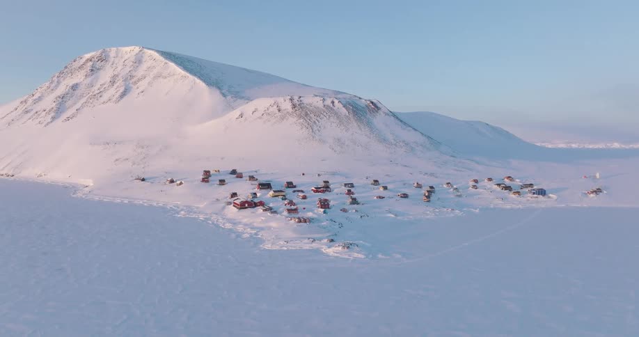 Mountain towers over a rural town on a snowy plain on a winter day