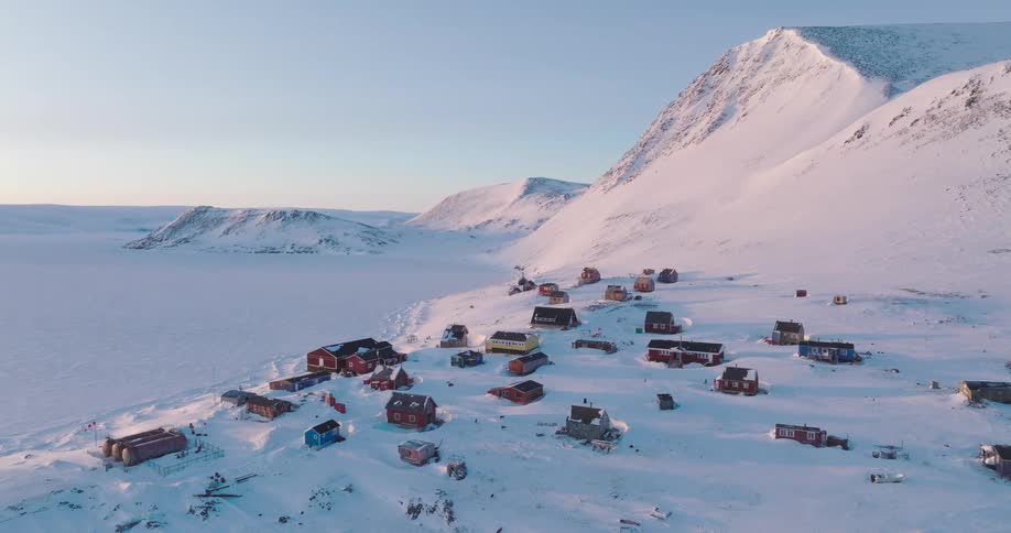Rural village on an arctic region surrounded by ice caps outdoors during dusk or dawn