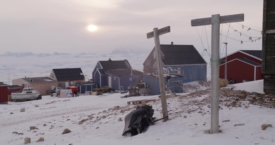 Clotheslines stand near a building in a snowy town on a winter day