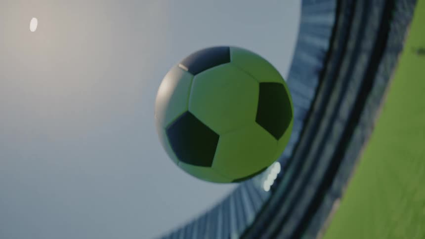 A soccer ball flies through the air on a field at sunset spinning as it drops toward the ground the warm orange light glows across its surface while it moves