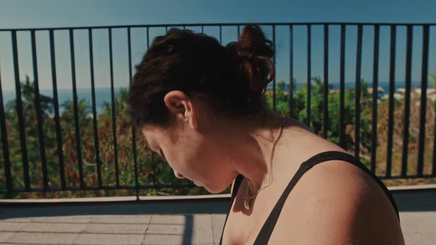 Woman doing yoga exercises on her balcony