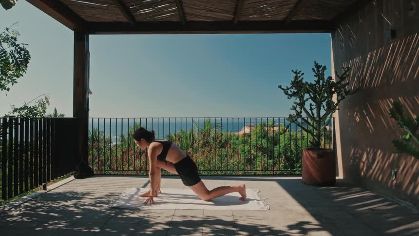 A woman doing yoga outdoors on a patio