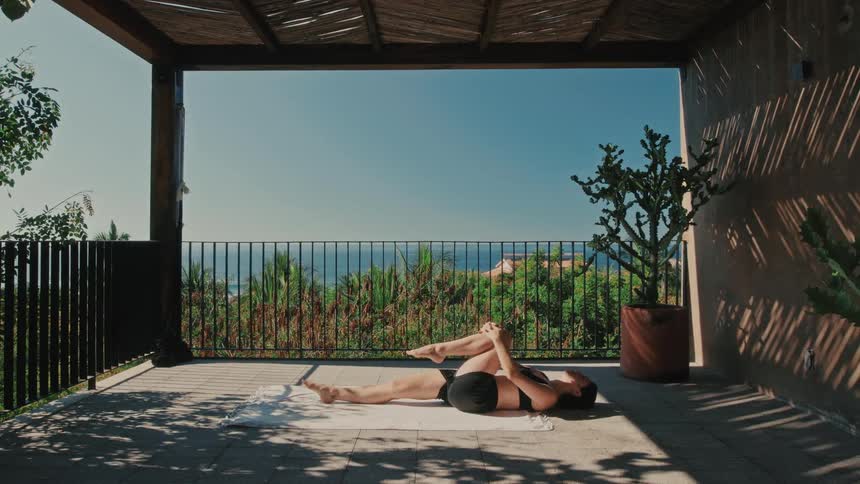 A woman doing yoga on a patio outdoors