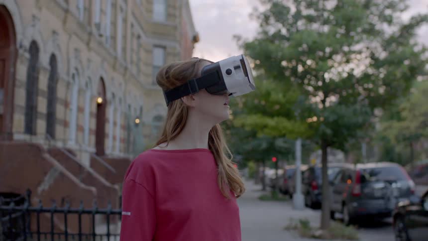 A woman wearing a virtual reality helmet looking around the city
