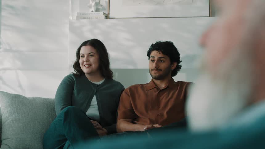 The couple smile and nod at a counseling session