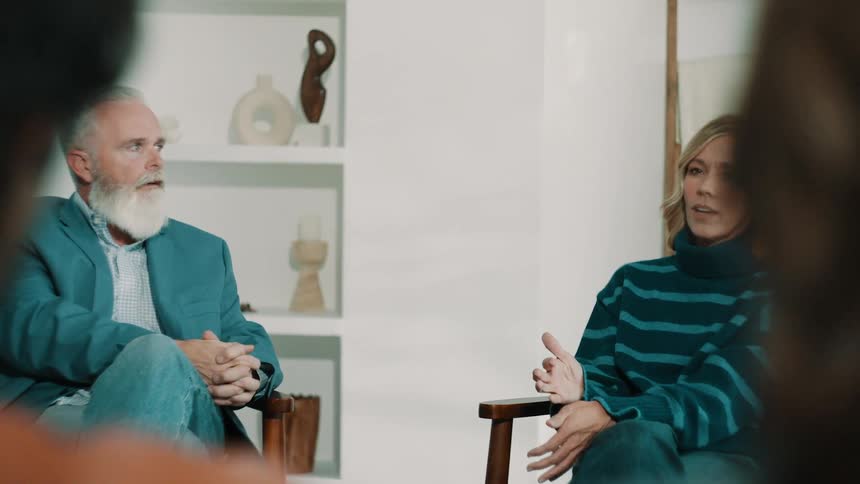 Couple talking while seated in armchairs during a meeting in an indoor setting