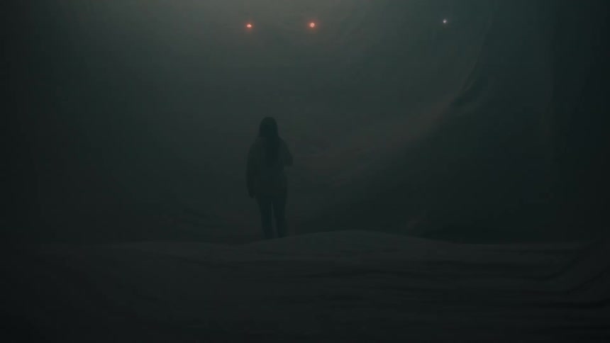 The woman stands in a room full of flashing lights and fog