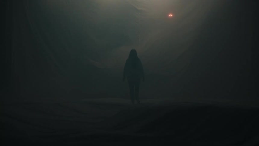 Person walking alone in a dark space with fog and lights in the background