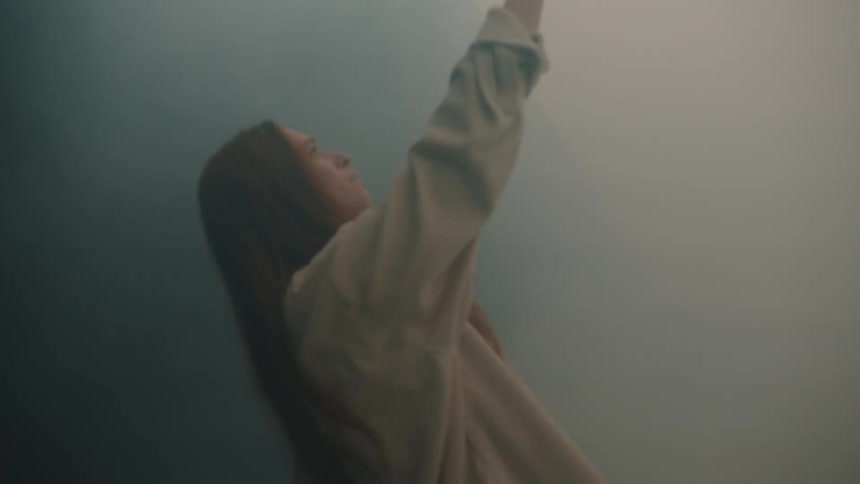 Lights quickly flash on the woman reaching her arm out