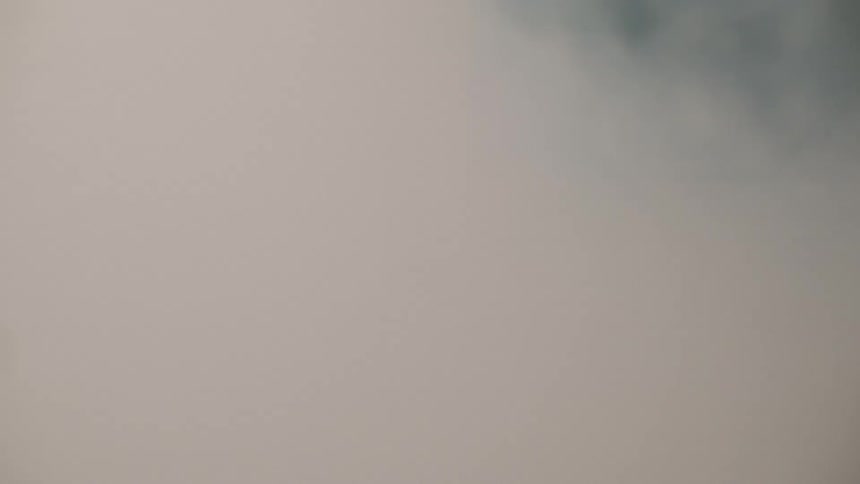 A tent filled with white smoke the drifting haze catching and reflecting light across the linen walls