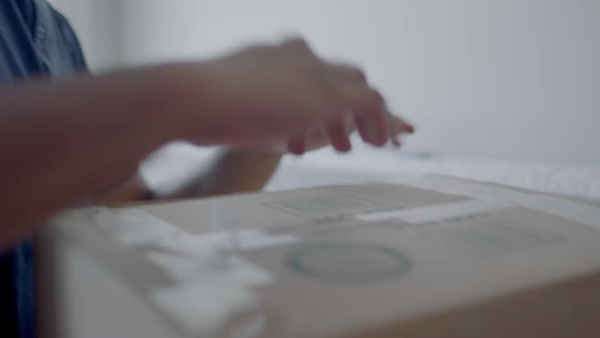 A person cuts a package with a pocket knife