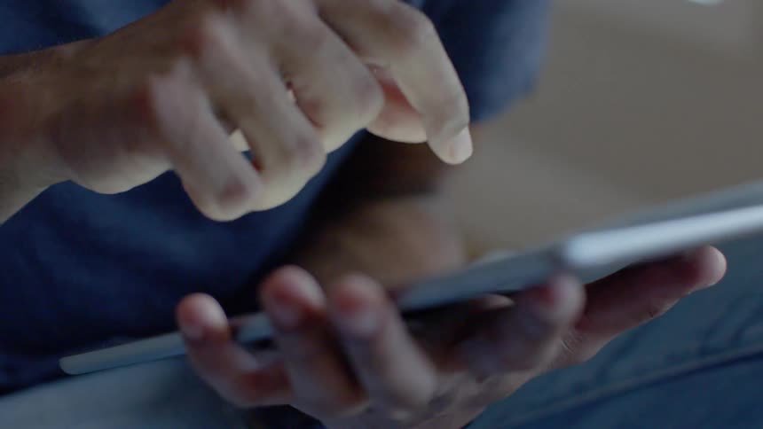 A man swipes on a tablet