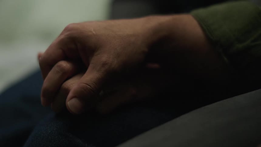 Adult man and adult woman holding hands indoors