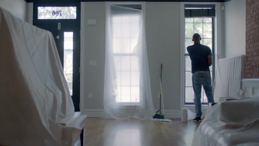 A man cleans a window with paper towels