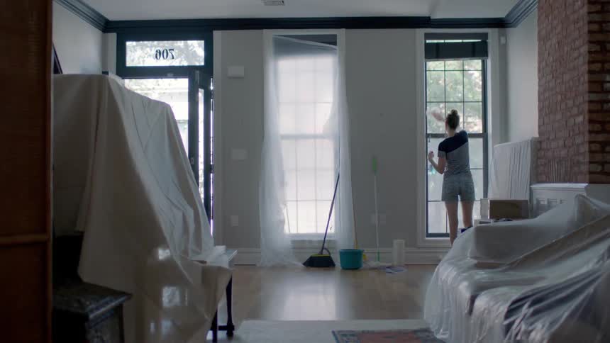 A woman scrubs an apartment window