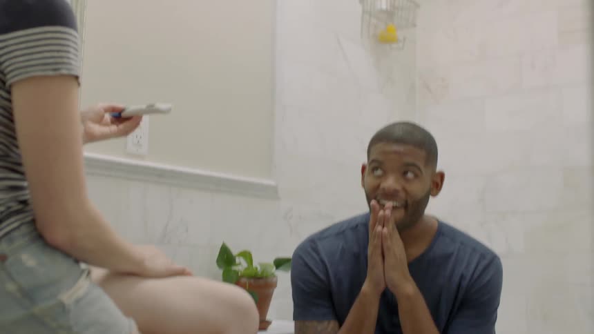 A man and woman are sitting in a bathroom