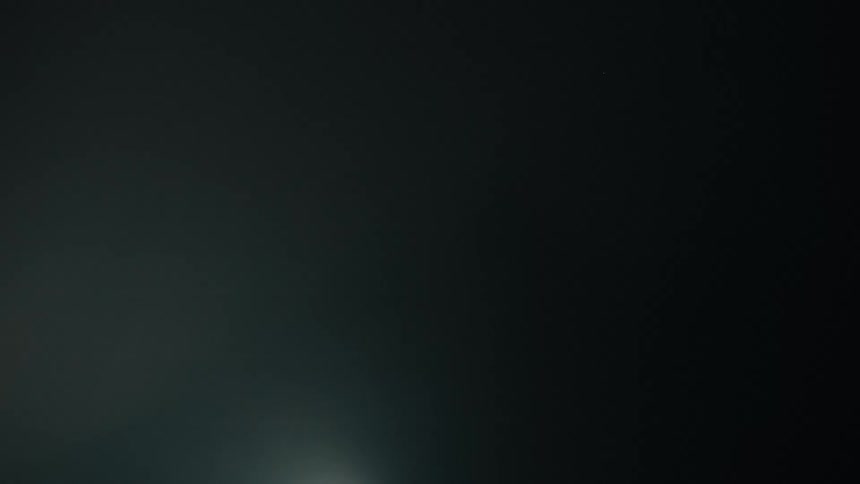 A woman reaches for a curtain on a foggy flashing stage