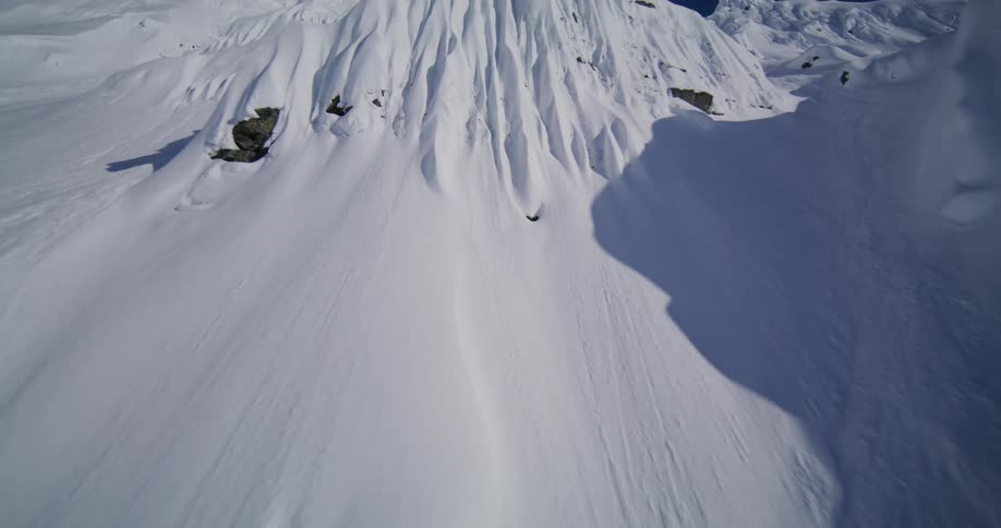 Sunlight shines on the rough terrain of snow covered mountains