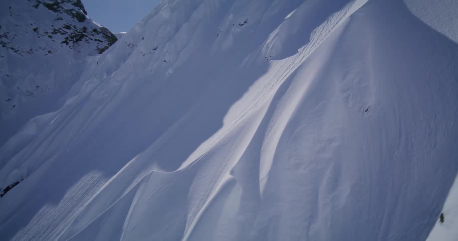 The tall mountains are covered in very white snow