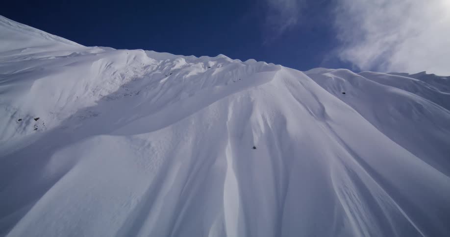 Snowcovered mountain slopes with natural ridges shaped by the terrain