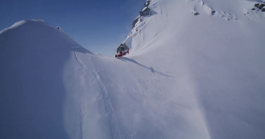 The helicopter flies on the peak of the mountain