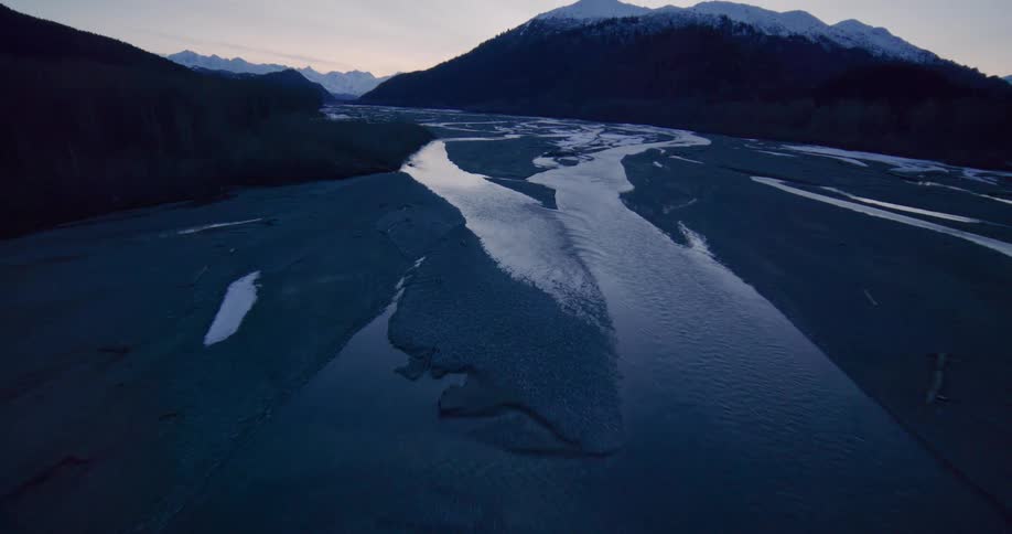 An aerial view of a river with mountains in the distance