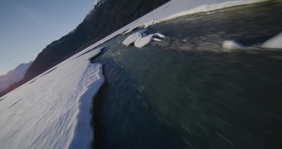 The stream is surrounded by snow and ice